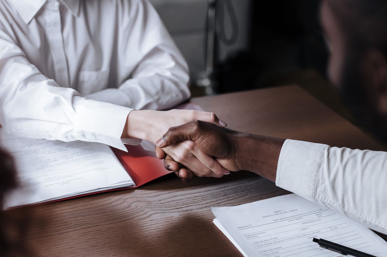 A handshake over project documents during implementation